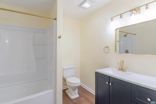 a bathroom with a toilet a sink a mirror and bathtub