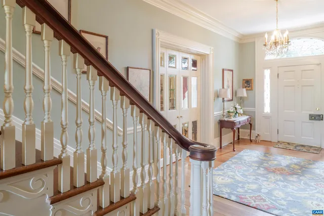 a view of staircase with wooden floor and a chandelier