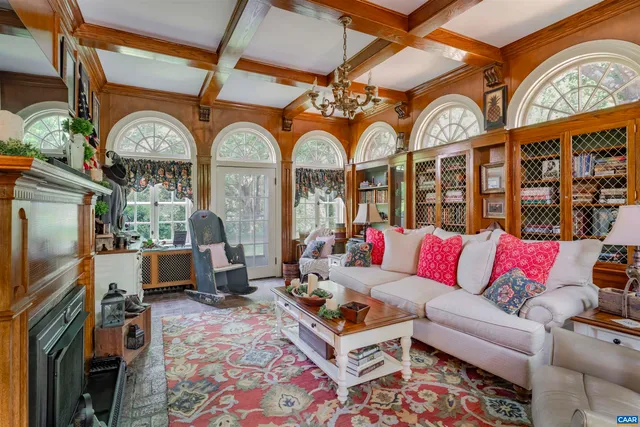 a living room with fireplace furniture and a rug
