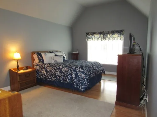 a bedroom with a bed mirror and window