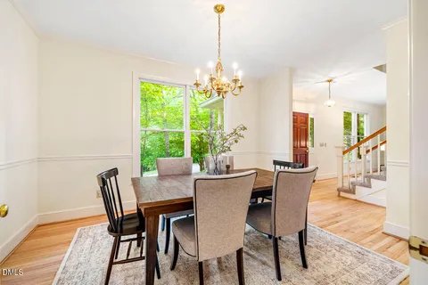 a dining room with furniture a chandelier and wooden floor