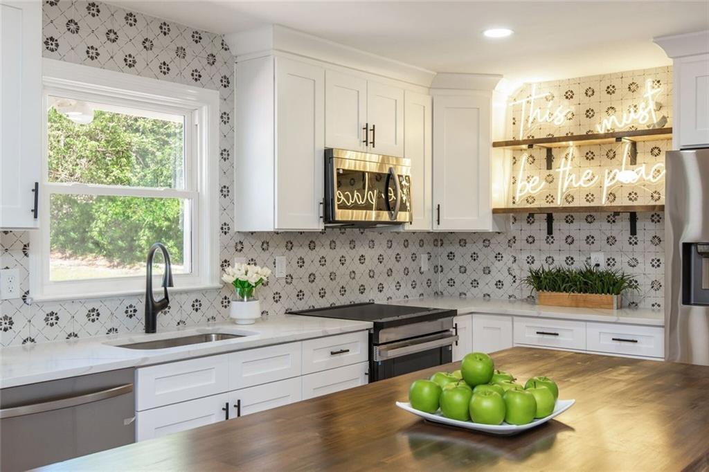 3365 Ardley Road Southwest Atlanta, GA 30311 - Photo 28 of 62 a kitchen with stainless steel appliances a sink and a window