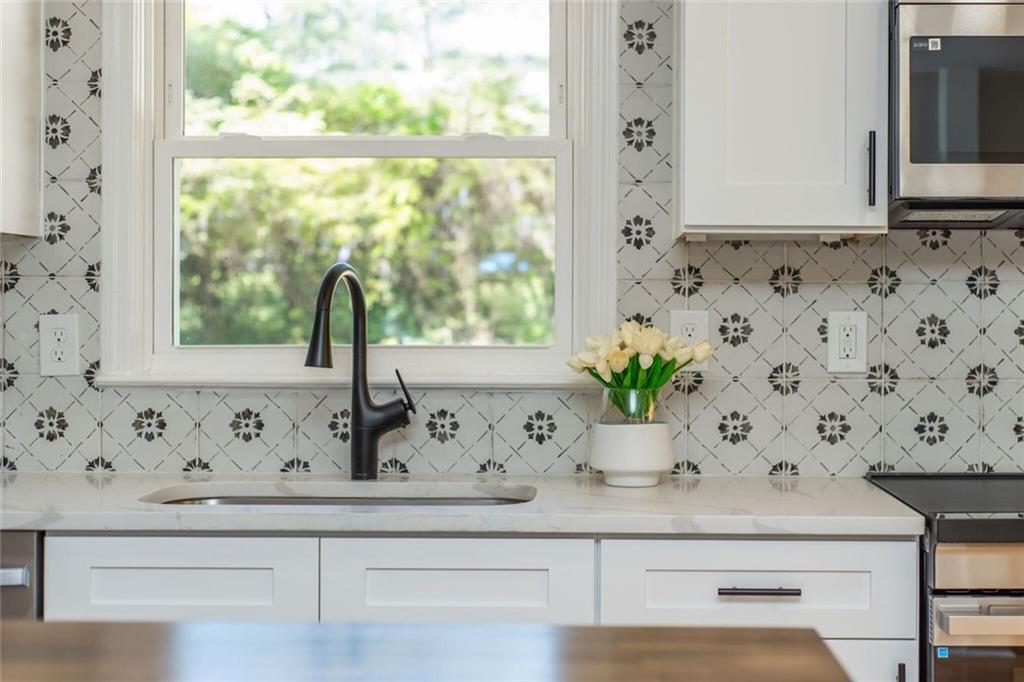 3365 Ardley Road Southwest Atlanta, GA 30311 - Photo 32 of 62 a view of a sink a mirror a window and a potted plant
