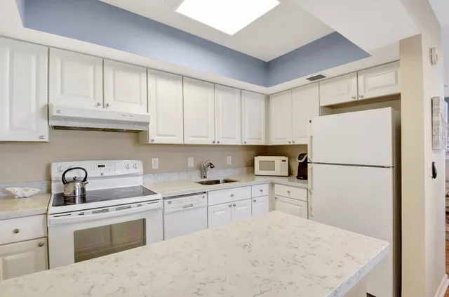 a kitchen with white cabinets and white appliances