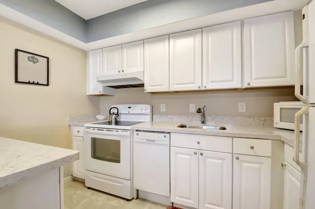 a kitchen with white cabinets and white appliances