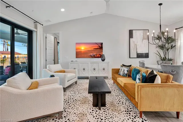 a living room with furniture a large window and a flat screen tv