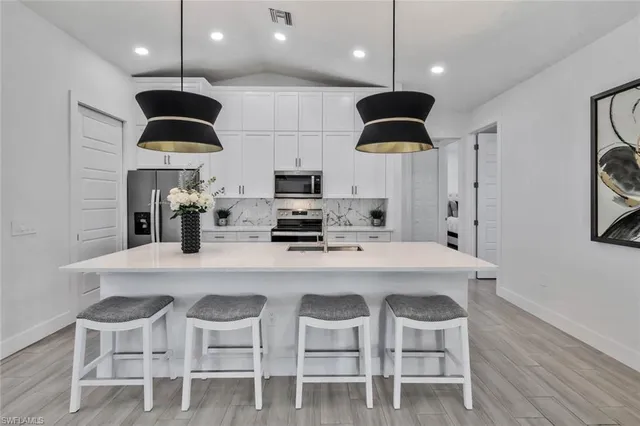 a kitchen with kitchen island stainless steel appliances a dining table and chairs