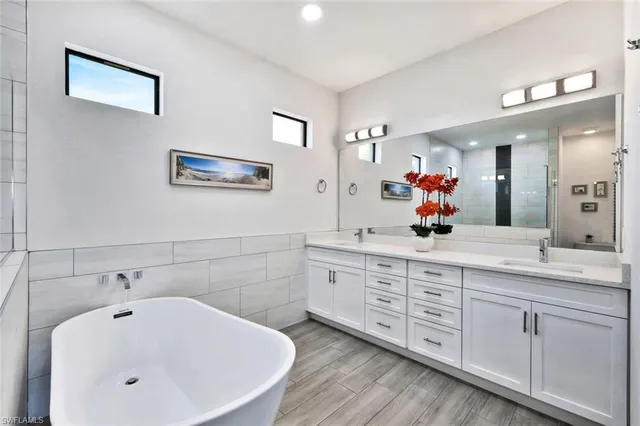 a bathroom with a tub sink and mirror