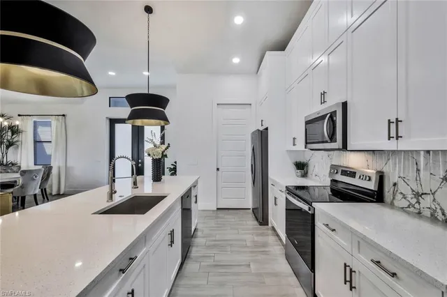 a kitchen with stainless steel appliances kitchen island a sink a stove and cabinets