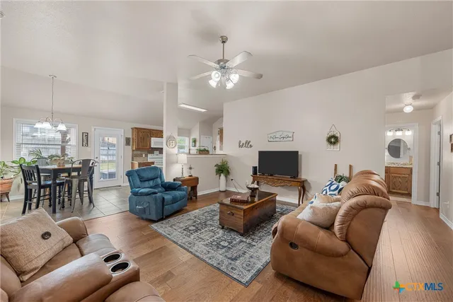 a living room with furniture a fireplace and a chandelier