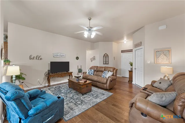 a living room with furniture and a wooden floor