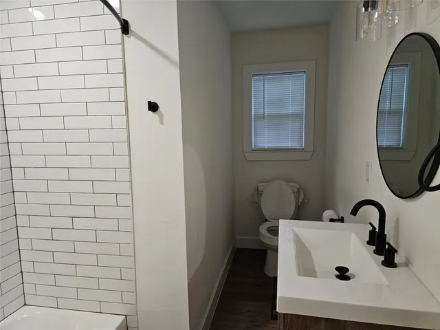 a bathroom with a sink a toilet and mirror