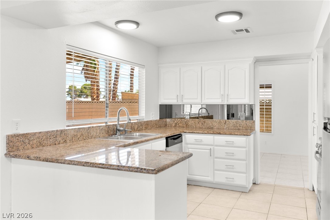 4430 Cranbrook Way Las Vegas, NV 89103 - Photo 11 of 50 A streamlined kitchen provides ample workspace, illuminated by natural light and overhead fixtures.