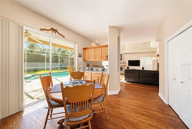 a view of a dining room with furniture a kitchen view and wooden floor