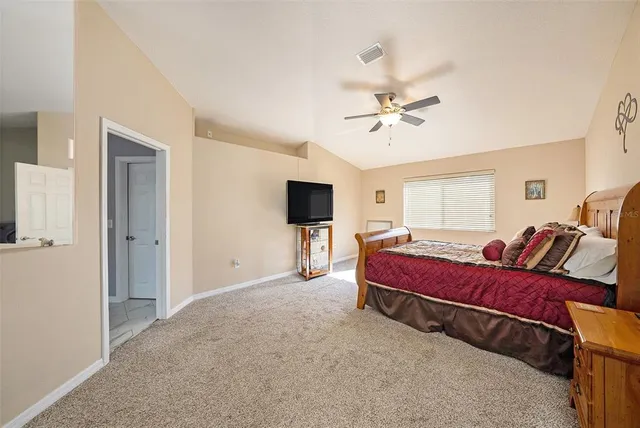 a spacious bedroom with a bed and a chandelier