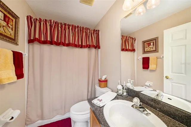 a bathroom with a sink vanity mirror and toilet