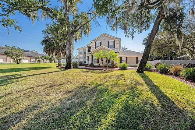 a front view of a house with a yard and trees