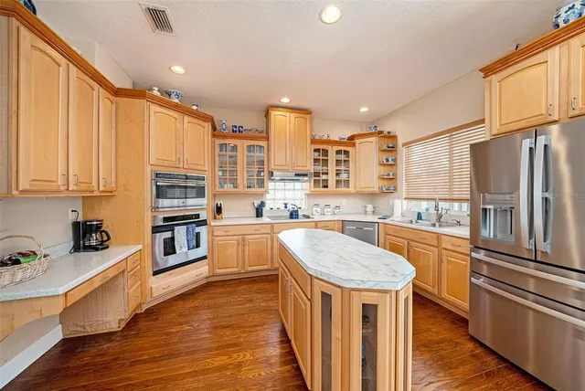 a kitchen with stainless steel appliances granite countertop a refrigerator a stove oven and white cabinets