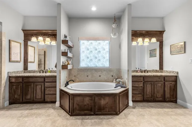 a spacious bathroom with a tub double sink and a large mirror