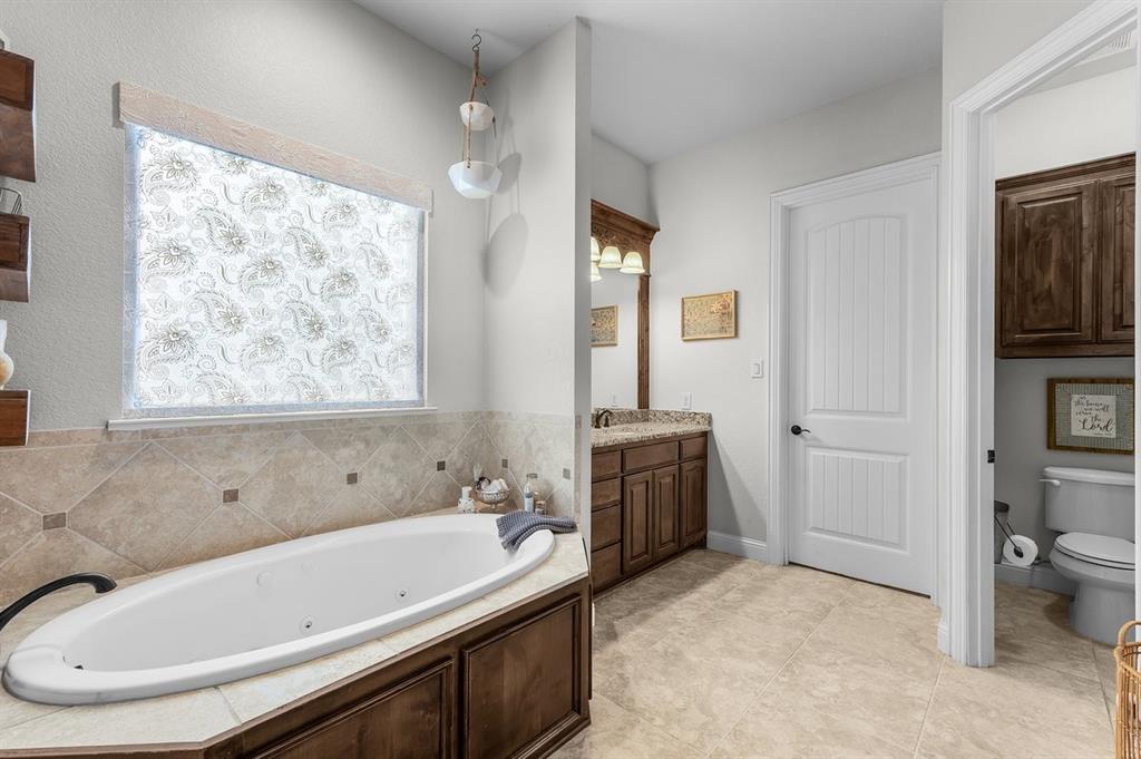 228 Parc Oaks Drive Aledo, TX 76008 - Photo 17 of 40 a bathroom with a tub a sink and a window
