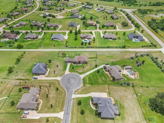 an aerial view of a swimming pool with a yard