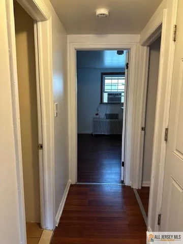 a view of a room with wooden floor and front door