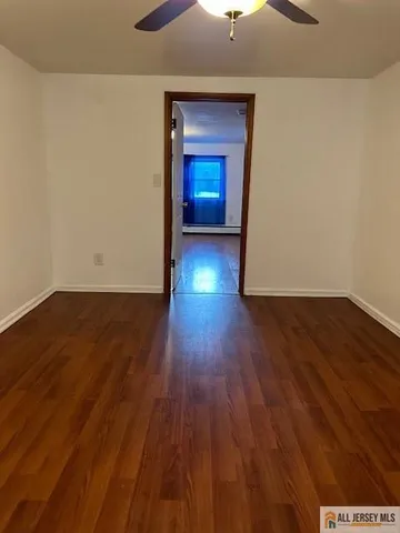 an empty room with wooden floor and closet