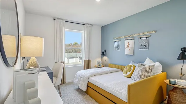 a bedroom with a bed a mirror and a large window