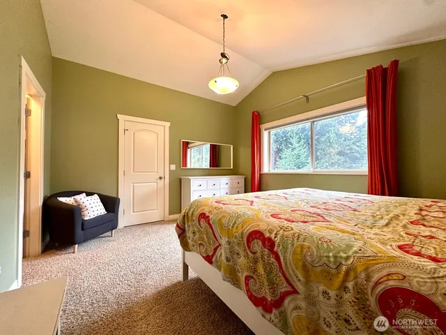 a bedroom with a bed and a flat tv screen on dresser
