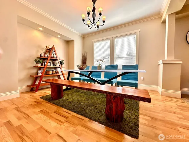 a living room with table chairs and a chandelier