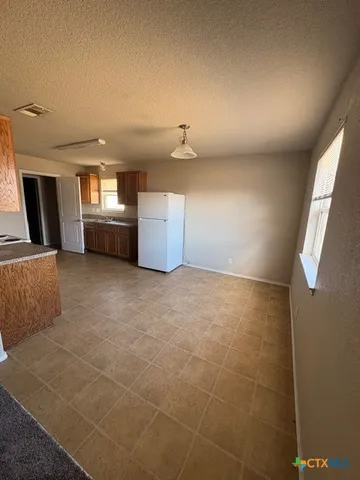 a view of a refrigerator in kitchen and utility room