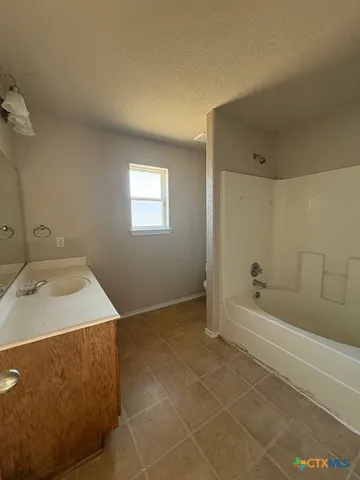 a bathroom with a bathtub sink and vanity