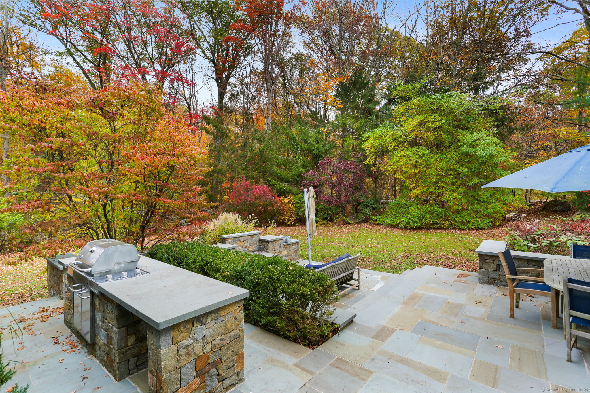 31 White Birch Road Weston, CT 06883 - Photo 32 of 37 a view of a patio with table and chairs under an umbrella