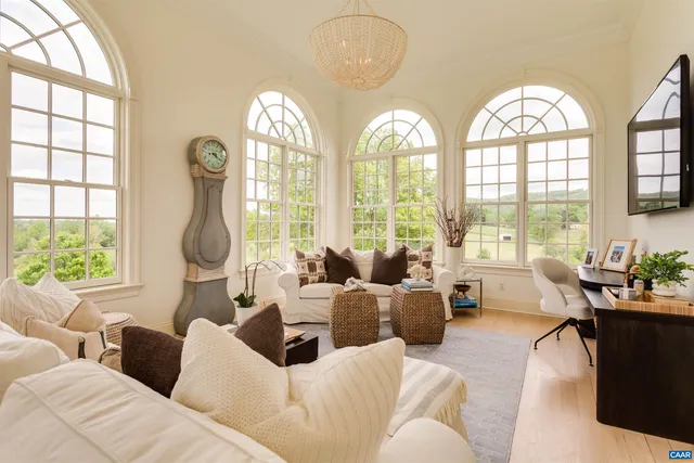 a living room with furniture a large window and a fireplace