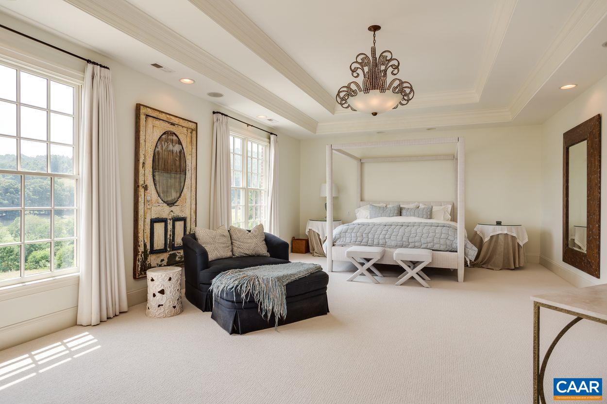 585 Ragged Mountain Drive Charlottesville, VA 22903 - Photo 27 of 60 a spacious bedroom with two beds and a chandelier