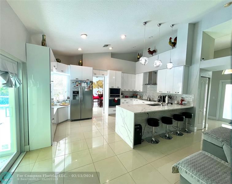 a kitchen with stainless steel appliances kitchen island granite countertop a refrigerator and a sink