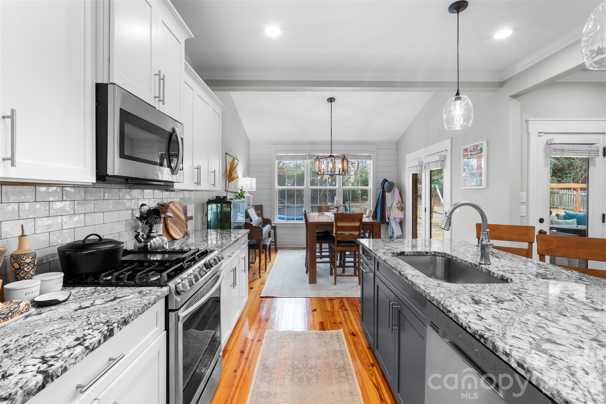 276 Belle Ridge Road Elgin, SC 29045 - Photo 12 of 45 a kitchen with granite countertop a stove a sink a oven a dining table and chairs
