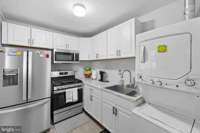 a kitchen with white cabinets and appliances