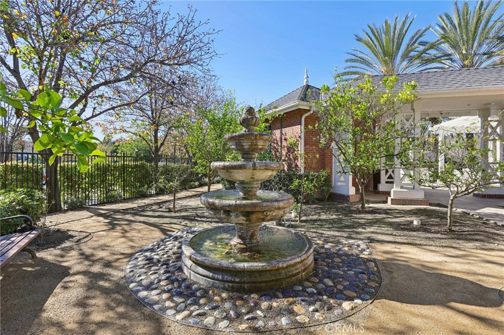 15 Whitworth Street Ladera Ranch, CA 92694 - Photo 36 of 57 a backyard of a house with fountain table and chairs potted plants and palm trees