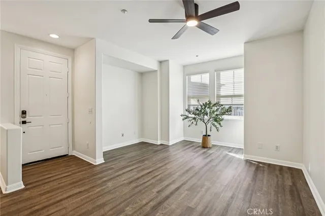 a room with wooden floor and a potted plant