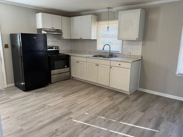 a kitchen with a sink a refrigerator and cabinets