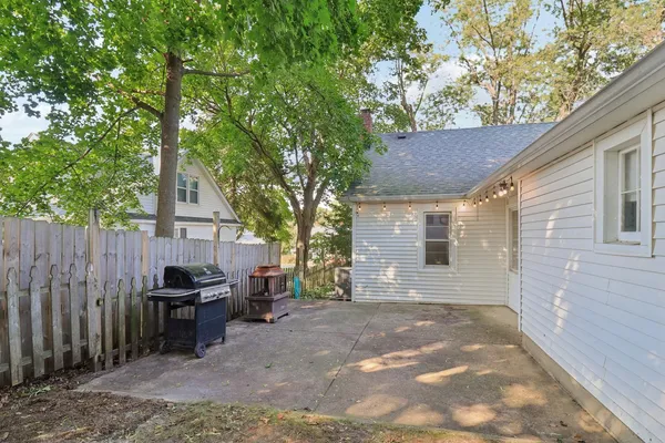 a backyard of a house with barbeque oven and seating space