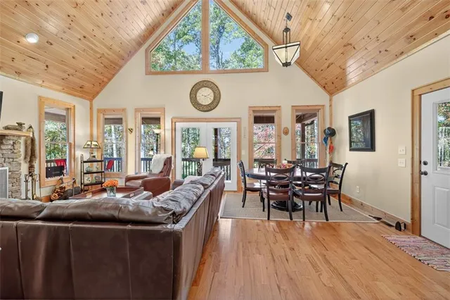 a living room with furniture a large window and wooden floors