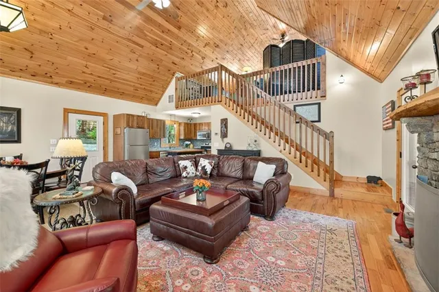 a kitchen with granite countertop a stove top oven a sink dishwasher and a refrigerator with wooden floor