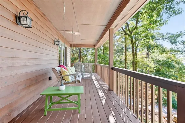 a balcony with wooden floor table and chairs