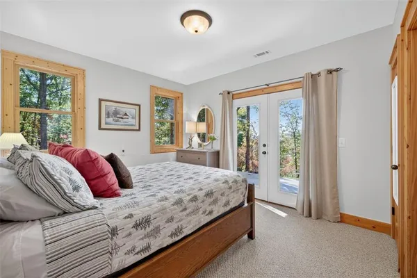 a bedroom with a large bed and a dresser next to a window