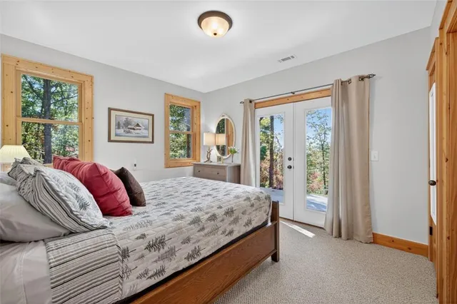 a bedroom with a large bed and a dresser next to a window