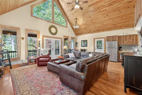 a living room with furniture a large window and wooden floors