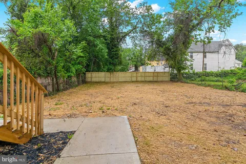 a view of a yard with wooden fence