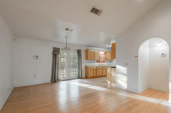 a view of a room with a chandelier and wooden floor